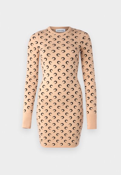 Vestido de malha em pêssego suave com padrão de lua crescente preta. Silhueta justa, gola redonda e mangas longas.