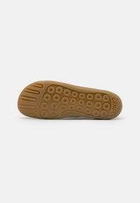Suola di gomma di colore beige, con motivi a impronta circolare, scanalature per aderenza e marchio in rilievo "CAMPER 42".
