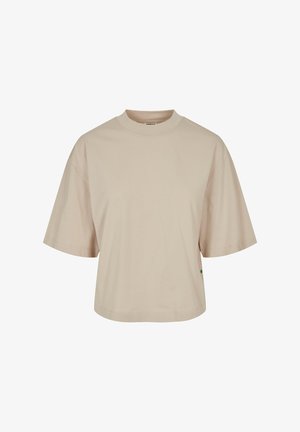 Béžové tričko s krátkym rukávom a okrúhlym výstrihom, vyrobené z bavlny. Má voľný strih a bočný detail s logom v zelenom odtieni.
