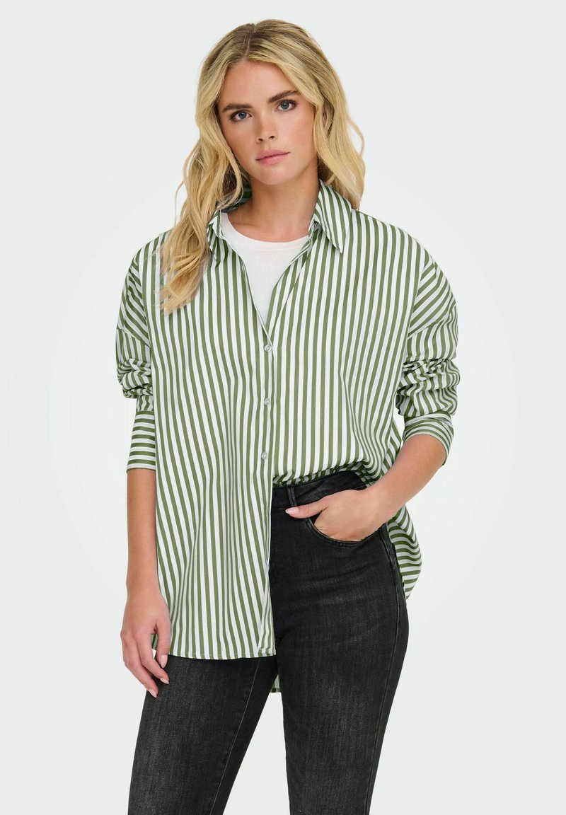Groen en wit gestreepte knoopshirt met lange mouwen, ontspannen pasvorm en een subtiele textuur, gecombineerd met donkere jeans.