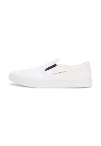 Άσπρα sneakers slip-on κατασκευασμένα από καμβά με λεία υφή και αντιθετική σκουρό μπλε λεπτομέρεια στο ελαστικό πλάι. Διαθέτουν ελαστική σόλα από καουτσούκ.