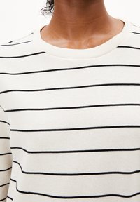 Bavlněná mikina s kulatým výstřihem, zdobená vodorovnými černými pruhy na krémovém podkladu. Hladká textura s žebrovaným límcem.