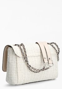 Sac blanc texturé avec une surface en tissu tissé, doté d'une anse en cuir crème et d'accents en chaîne argentée. Design avec fermeture rabat.