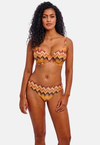 Juego de bikini con aros en un patrón de zigzag. Los colores incluyen naranja, marrón y amarillo. Textura suave con tirantes ajustables y cobertura mínima.