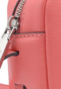 Borsa a mano corallo realizzata in materiale sintetico testurizzato, chiusura con cerniera argento, cuciture rinforzate e tracolla removibile.