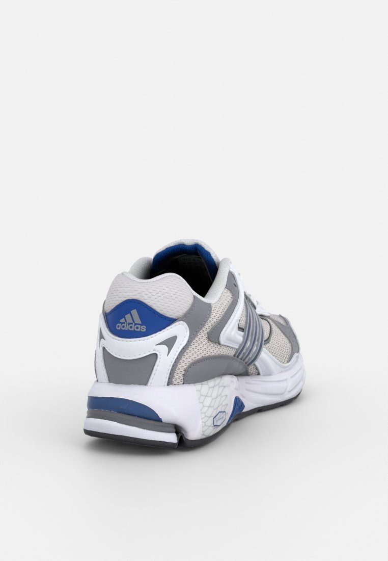 Zapatilla deportiva en gris y blanco con acentos en azul, parte superior de malla y sintético, suela acolchada y detalles texturizados en el talón y los lados.