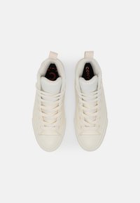 Baskets montantes en cuir crème avec lacets blancs, bout renforcé et boucle à la cheville. Semelle intérieure noire avec détail de branding rouge.