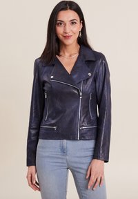 Giacca da motociclista in pelle blu navy con cerniere argentate, colletto a portafoglio e due tasche frontali con zip. Texture liscia e design aderente.