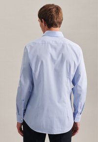 Camicia a maniche lunghe azzurro chiaro a quadri con colletto button-down, slim fit e maniche con polsini. Tessuto morbido e design dell'orlo curvo.