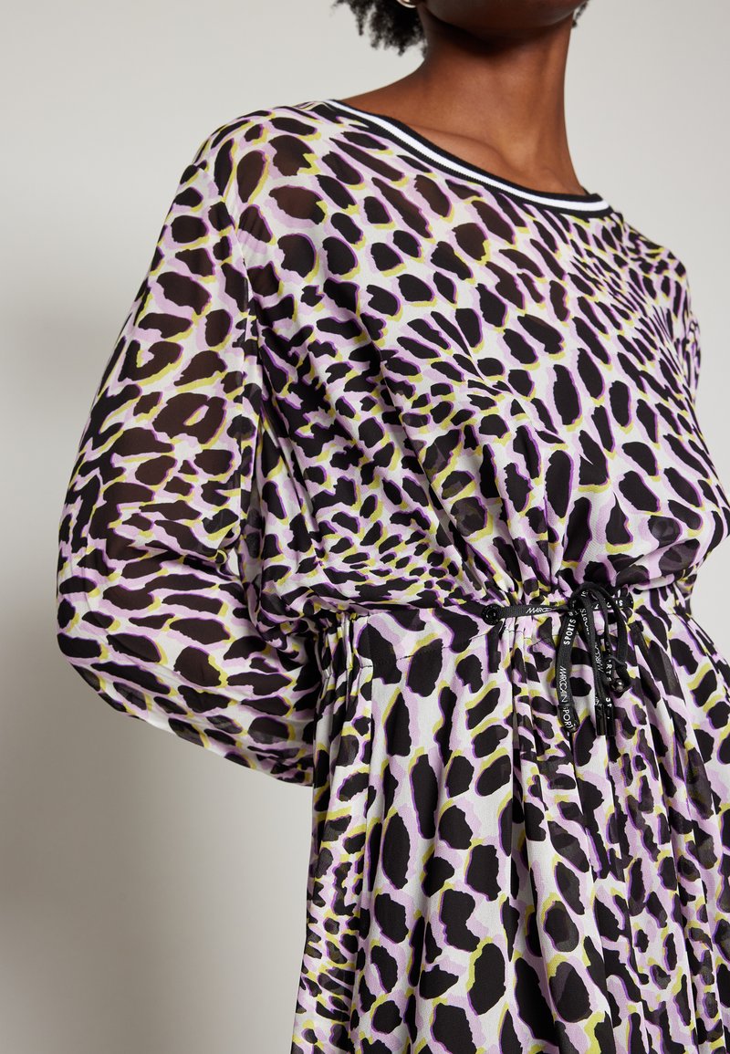Sheer dress with black, purple, and green leopard print. Features a drawstring waist and a striped neckline. Soft, flowing fabric with long sleeves.