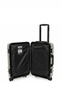 Tvrdý kufr světlezelené barvy s černým interiérem. Mezi jeho vlastnosti patří teleskopická rukojeť, hladké kolečka a síťová kapsa pro organizaci.