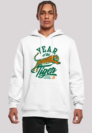 White hoodie with a front kangaroo pocket. Features a colorful graphic of a tiger, "YEAR of the TIGER," and "HAWKINS HIGH SCHOOL '86" in bold text.
