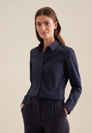 Camicia blu navy a maniche lunghe, con colletto a punta, realizzata in un tessuto morbido e caratterizzata da una vestibilità su misura e dettagli con tasca.