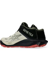 Buty biegowe GORE-TEX w wysokim kroju, z kremową cholewką, czarnymi akcentami i teksturowaną czerwoną podeszwą zewnętrzną zapewniającą lepszą przyczepność.