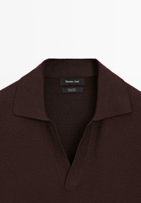 Brun bomulds polo shirt med et tekstureret design, der har en V-hals og en flad krave. Klistermærket viser "Massimo Dutti."