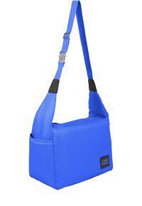 Borsa a spalla blu realizzata in materiale leggero, con forma rettangolare, tracolla regolabile e un'etichetta con logo, dalla superficie liscia.