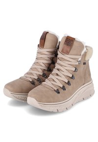 Brązowe buty trekkingowe z zamszowej cholewki, teksturowanymi sznurówkami, sztucznym futrem na kołnierzu i wyściełaną podeszwą. Posiadają czarne oczka i skórzaną metkę.