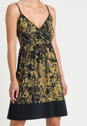 Robe noire avec motif floral doré, décolleté en V, fines bretelles, taille élastique et ourlet noir. Tissu léger avec un design fluide.