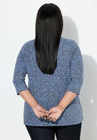 Lange mouwen top in lichtblauw met een zwart luipaardprintpatroon. Zacht materiaal met een losse pasvorm en licht afgeronde zoom.