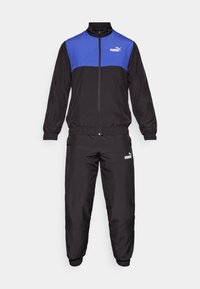 Schwarzer Trainingsanzug aus leichtem Material. Mit einem blauen Einsatz im oberen Bereich der Jacke, elastischen Bündchen und einem elastischen Bund. Enthält PUMA-Logo-Akzente.