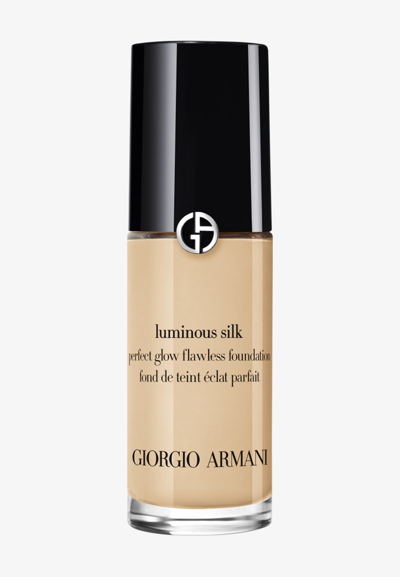 Flacon de fond de teint liquide Giorgio Armani Luminous Silk avec un bouchon noir et un produit beige à l'intérieur, étiqueté "perfect glow flawless foundation."