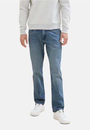 Jeans in denim blu chiaro con una vestibilità dritta, dotati di cinque tasche e leggera scoloritura. Abbinati a sneakers bianche e a una felpa grigia chiara.