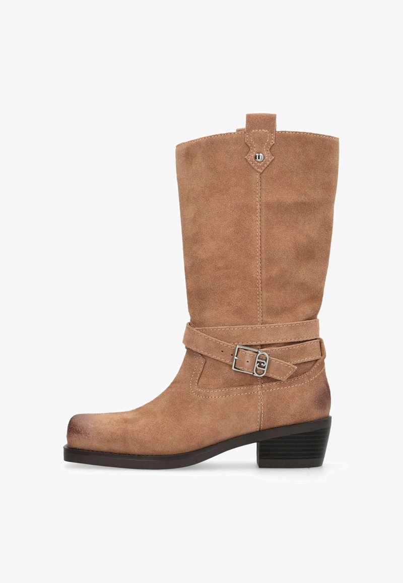 Botte montante en daim de couleur marron clair, avec une sangle à boucle et un bout légèrement arrondi. Talon bas empilé et dessus texturé.