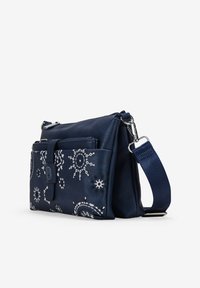Bolso de mano de cuero navy con acentos en blanco con patrones, compartimentos con cremallera, correa ajustable y superficie texturizada. Forma rectangular.