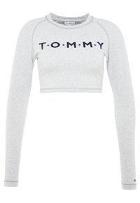 Grau geschnittenes Langarmoberteil aus weichem Stoff, mit "TOMMY" in navyfarbener Schrift und Sternelementen über der Brust.