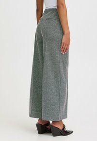 Graue Herringbone-Weitbein-Hosen mit hoher Taille, ausgestattet mit Gesäßtaschen, einer glatten Textur und weiten Abschlüssen an den Säumen.