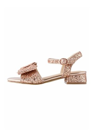 Glitrende rosaguld sandal med flad blokhæle, rem med spænde, og en stor sløjfeaccent foran. Skinnende metallisk finish.