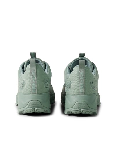 Pár světle zelených sportovních bot zobrazených zezadu, s texturovanou tkaninou, poutky a silnými gumovými podrážkami.