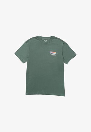 T-shirt di cotone verde scuro con maniche corte e scollatura rotonda. Presenta un piccolo logo colorato di Billabong sulla parte sinistra del petto.