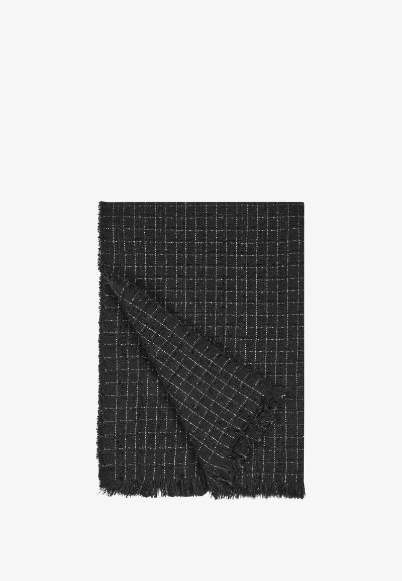 Coperta nera intrecciata con motivo a griglia bianca, con bordi frangiati e una texture morbida, piegata per mostrare lo strato interno.