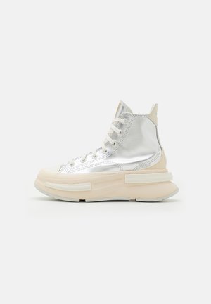 Hoogtop sneakers in metallic zilver met een beige zool. Kenmerken zijn een gestructureerde bovenkant, vetersluiting en een opvallend platformontwerp.