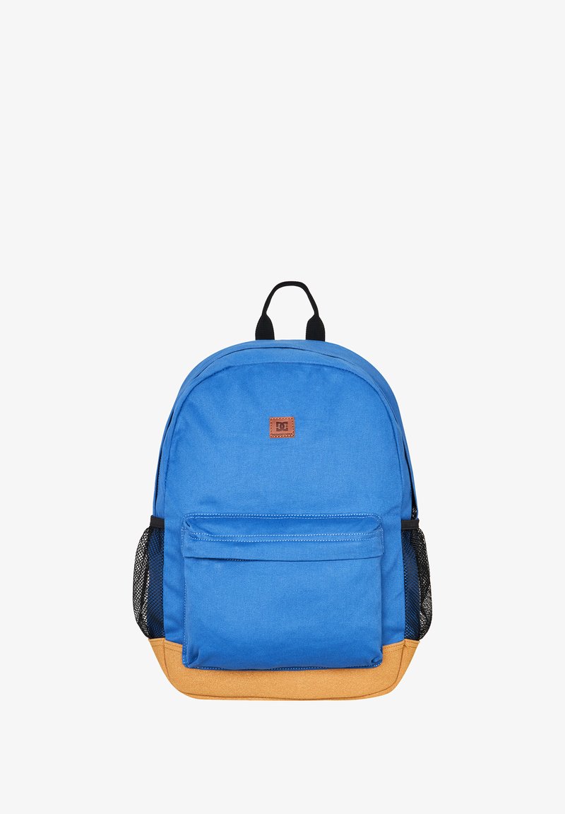 Blauer Stoff-Rucksack mit einem braunen Logo-Patch, frontalem Fach und gelbem Boden. Verfügt über schwarze Netzseitentaschen und zwei obere Tragegriffe.