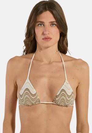 Donna con lunghi capelli castani che indossa un top bikini a triangolo beige e bianco con motivo, su uno sfondo semplice.