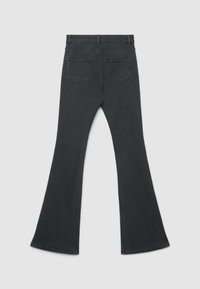 Jeans neri a zampa con una texture liscia, cinque tasche e una vita media. L'orlo è ampio, estendendosi in una silhouette a zampa.