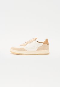 Weiße und beige Sneaker aus Leder und Wildleder. Merkmale sind Perforationen, runde Schnürsenkel und eine strukturierte Gummisohle mit Branding an der Ferse.