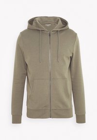 Sudadera con capucha color verde oliva y cremallera, con un bolsillo frontal, cordones y puños acanalados. Hecha de tela suave y lisa con un ajuste relajado.