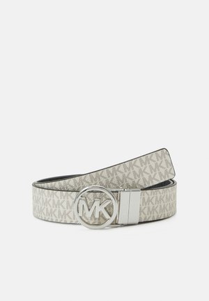 Ceinture beige avec motif répété du logo MK et boucle circulaire argentée ornée des lettres MK en relief, présentée enroulée sur un fond blanc.