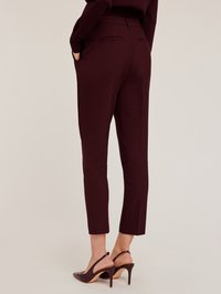 Pantalons sur mesure bordeaux à coupe slim, dotés de poches latérales et de poches arrière, associés à des escarpins bordeaux à talons ouverts.