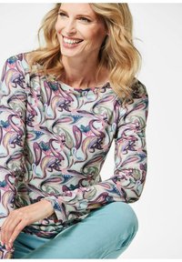 Langärmliges Shirt mit lila und pastellfarbener Blumenmuster auf einem hellen Hintergrund, aus weichem Stoff. Runder Halsausschnitt und taillierte Passform.