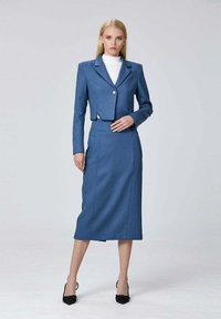 Veste ajustée bleue au design court et à bouton unique, associée à une jupe crayon assortie. Tissu lisse avec une finition élégante.