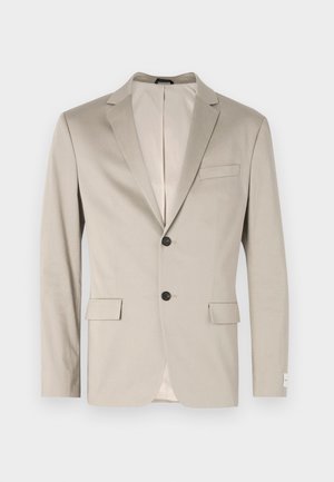 Beige bomullsblazer med en strukturerad design, slagkrage, två framfickor, enknappsstängning och kontrasterande innerfoder.