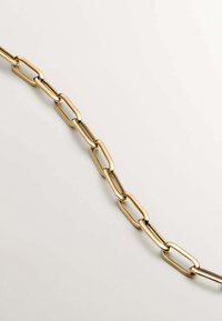 Collar de cadena de oro con eslabones ovalados alargados, textura suave y acabado pulido, exhibido sobre un fondo claro.