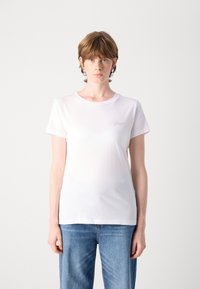 T-shirt bianca in cotone con maniche corte, scollatura rotonda, caratterizzata da un logo ricamato discreto sul lato sinistro. Design semplice e aderente.
