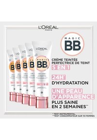 Tubes de crème BB Magic de L'Oréal Paris en blanc avec des accents roses, affichant des promesses d'hydratation et de perfectionnement de la peau ; empilés dans un agencement clair.