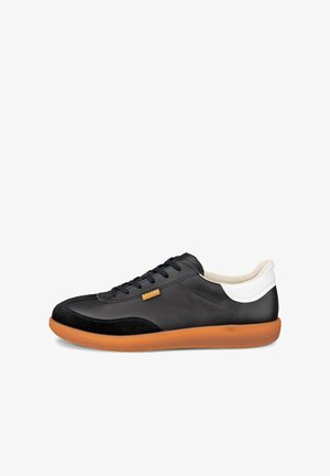 Zwarte lage sneaker met een bruine rubberen zool, wit hielstuk, zwarte veters en een kleine beige accent bij de veterklep aan de zijkant.