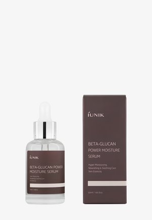 Heldere glazen druppelfles en donkerbruine doos met het label Beta-Glucan Power Moisture Serum van iUNIK voor hydratatie en huidverzorging.